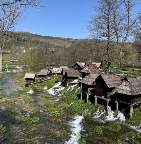 Traditional wooden watermills lined up across the channels between the Pliva Lakes near Jajce