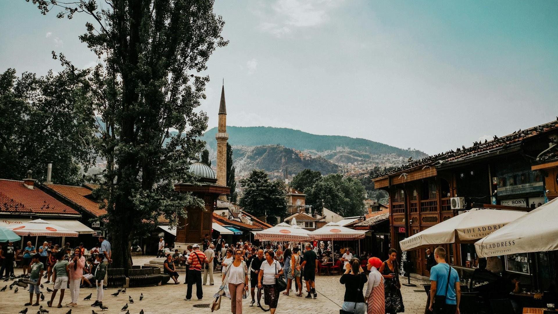 The Ottoman-era Bascarsija old bazaar of Sarajevo with minarets and red rooftops below green hills
